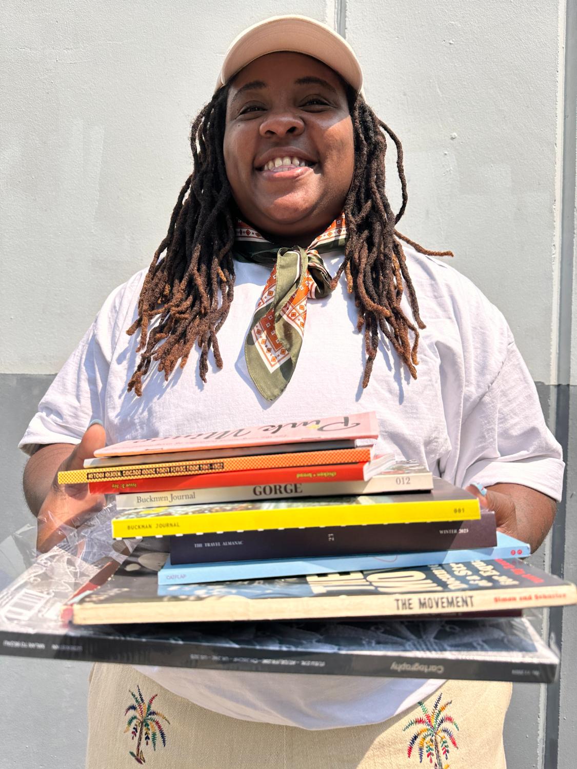 Gem holding a stack of independent magazines
